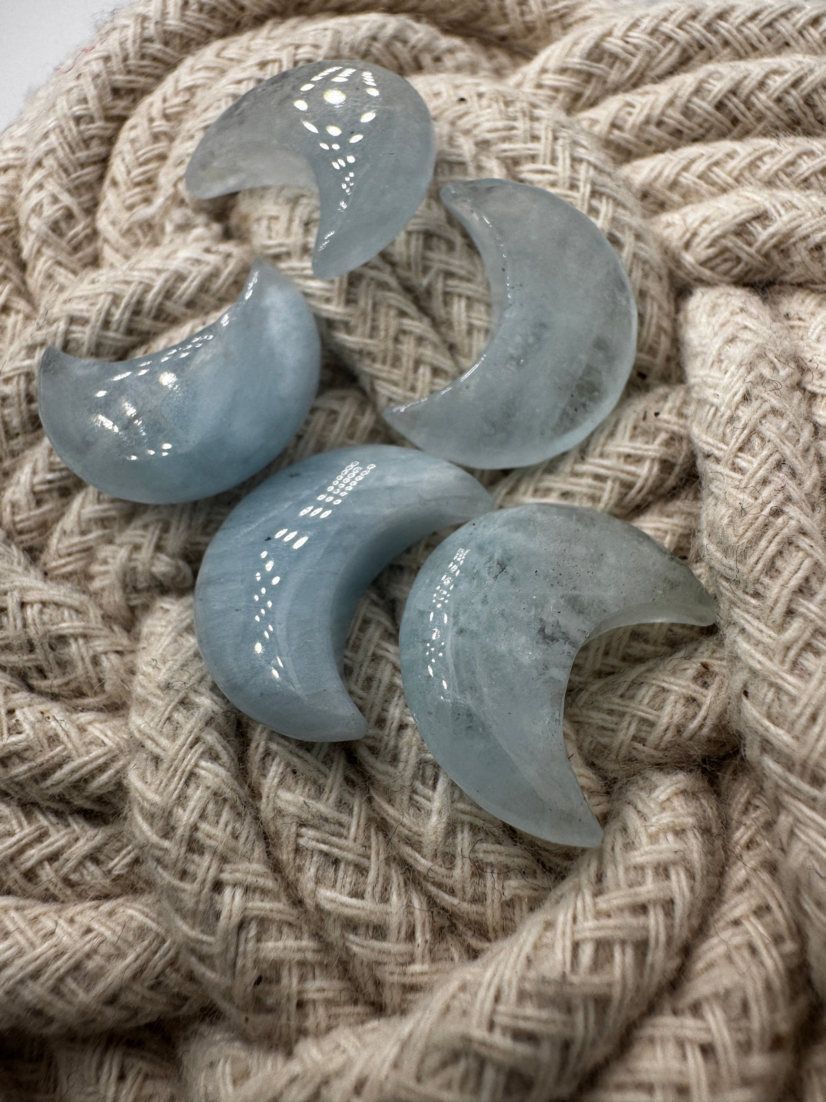 Handgefertigtes Carving aus Aquamarin in Mondform, helles eisenblaues Beryll-Mineral mit natürlicher Transparenz.