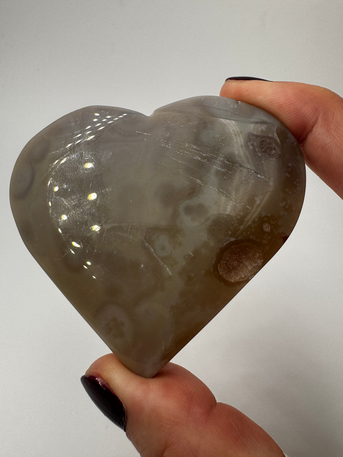 Herzförmiges Carving aus tiefviolettem Amethyst und gebändertem Achat.