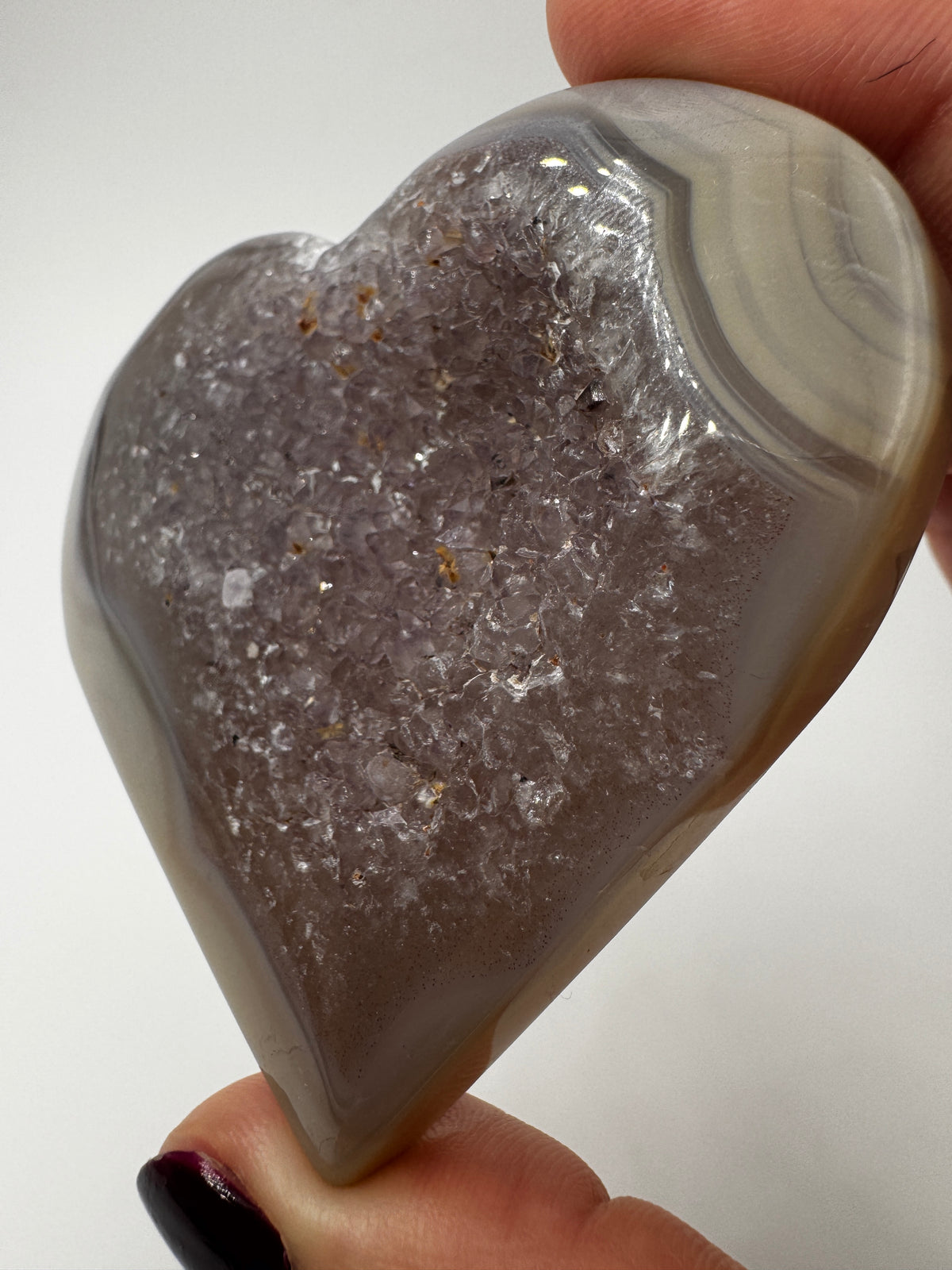 Herzförmiges Carving aus tiefviolettem Amethyst und gebändertem Achat.