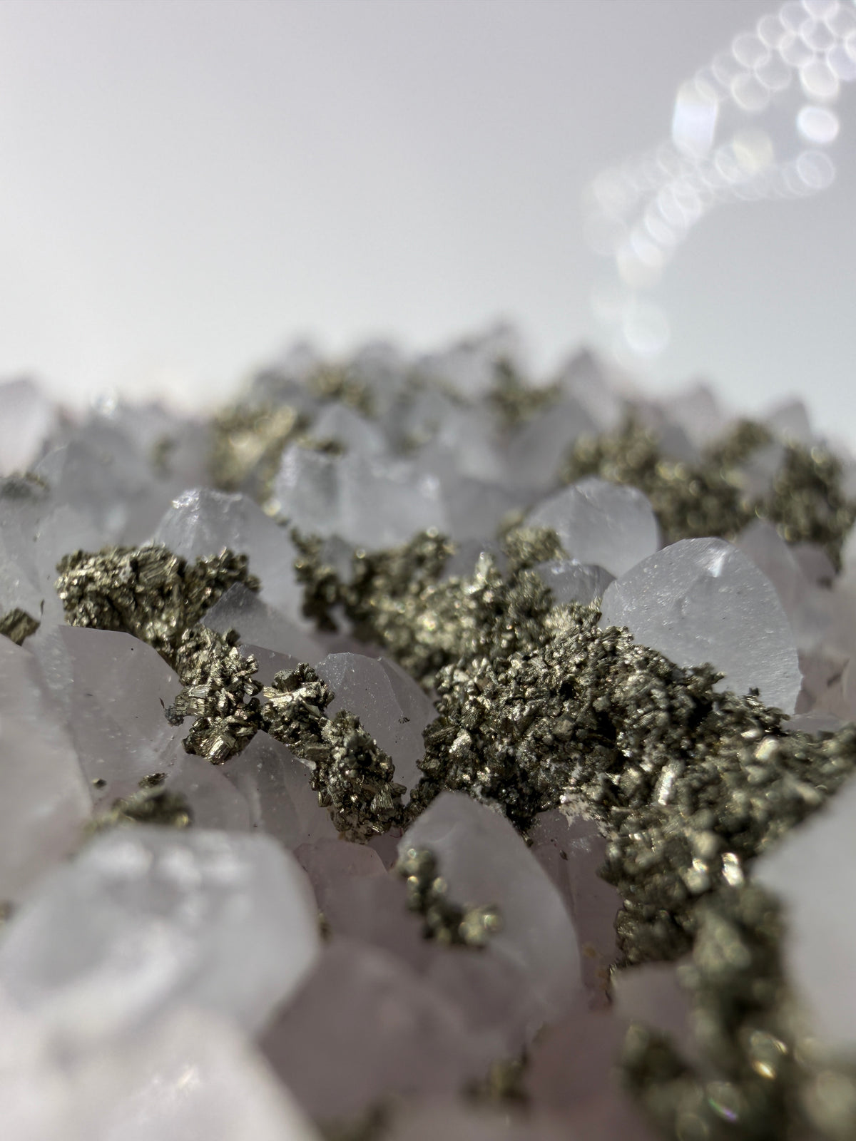 Blasser Amethyst in Weiß bis Hellviolett mit aufgewachsenem Pyrit und Quarz, Davidkovo Mine Bulgarien.