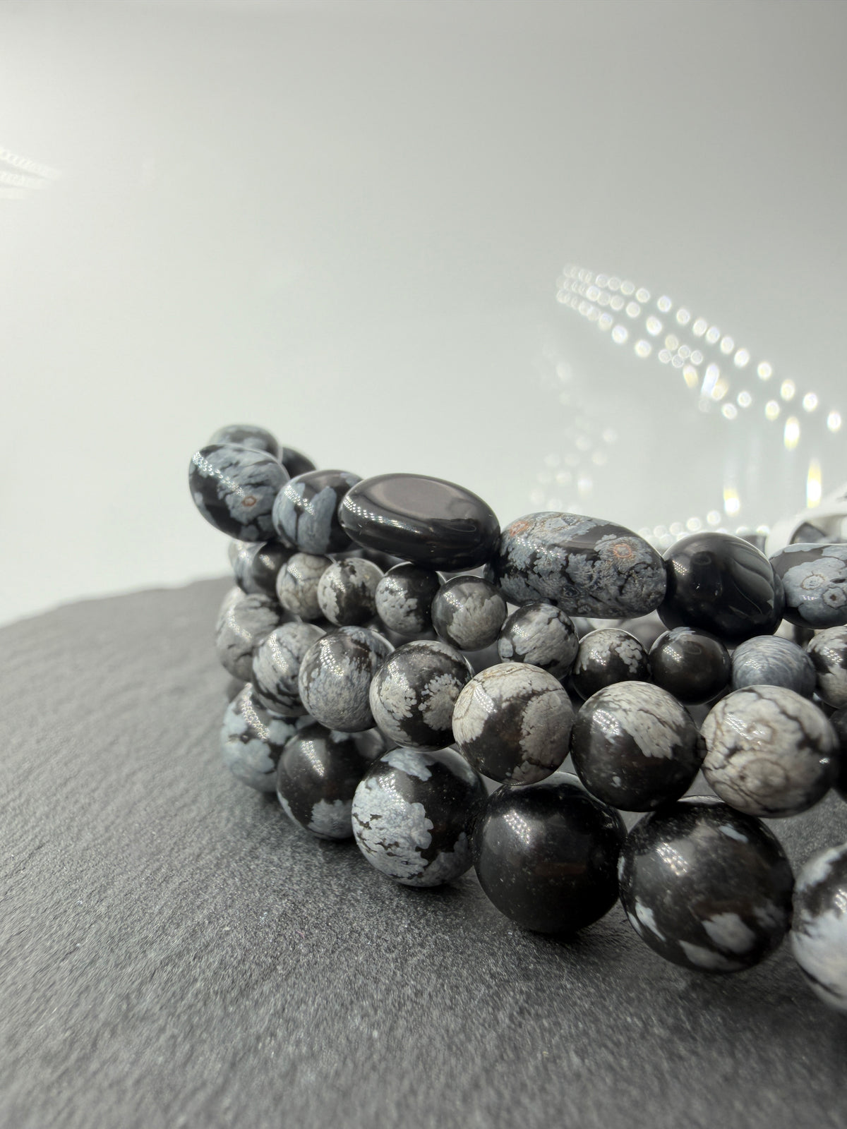 Kugelarmband aus Schneeflocken-Obsidian mit markanten weißen Cristobalit-Einschlüssen auf schwarzem Grund.