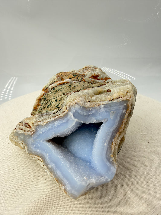 Blauer Chalcedon Rohstein BC42 mit sichtbarer Druze, ca. 9,8 × 8,9 × 5,7 cm, Nahaufnahme auf weißem Hintergrund