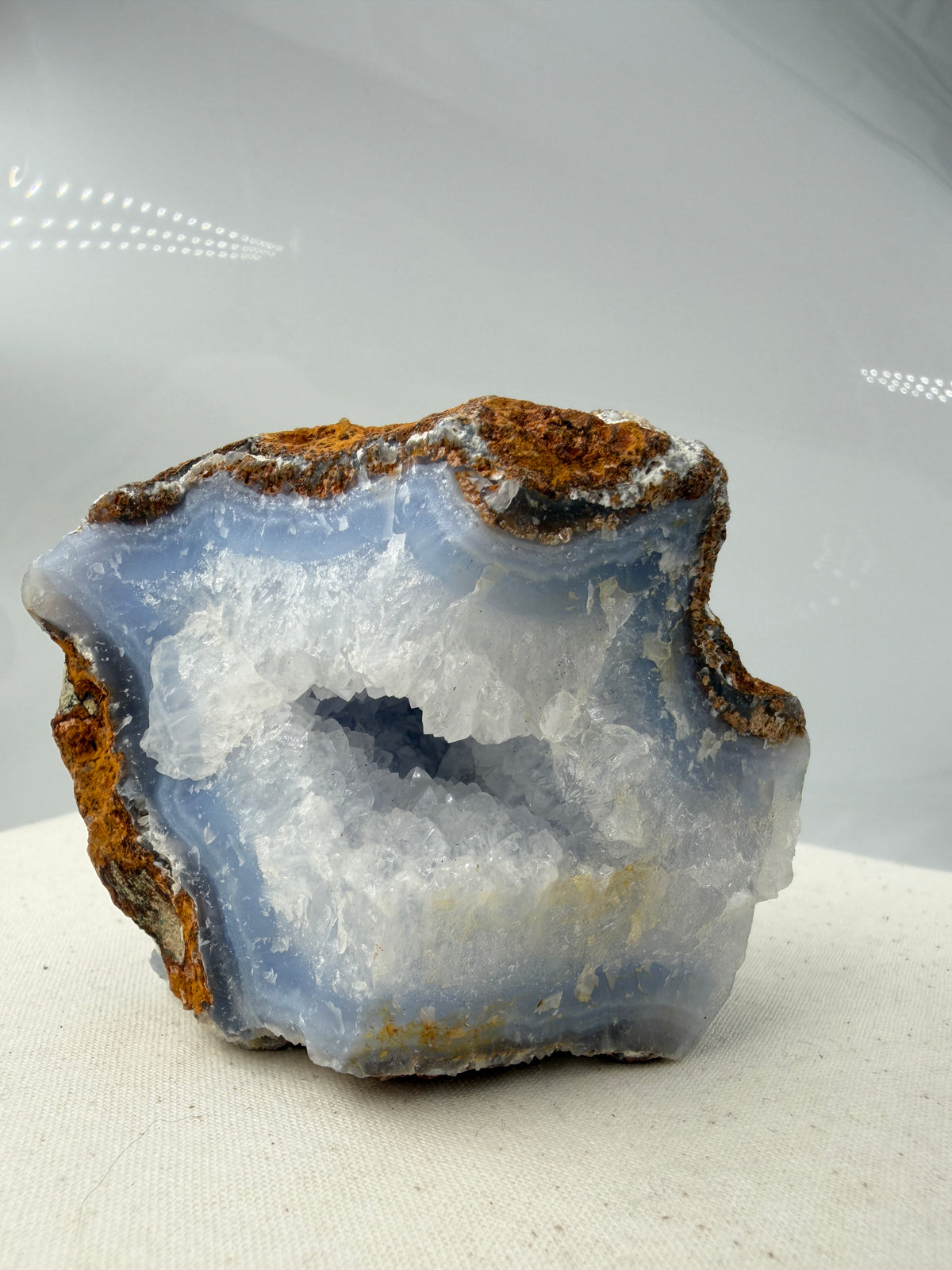 Blauer Chalcedon Rohstein BC46 mit sichtbarer Druze, ca. 8 × 8 × 6 cm, Nahaufnahme auf weißem Hintergrund