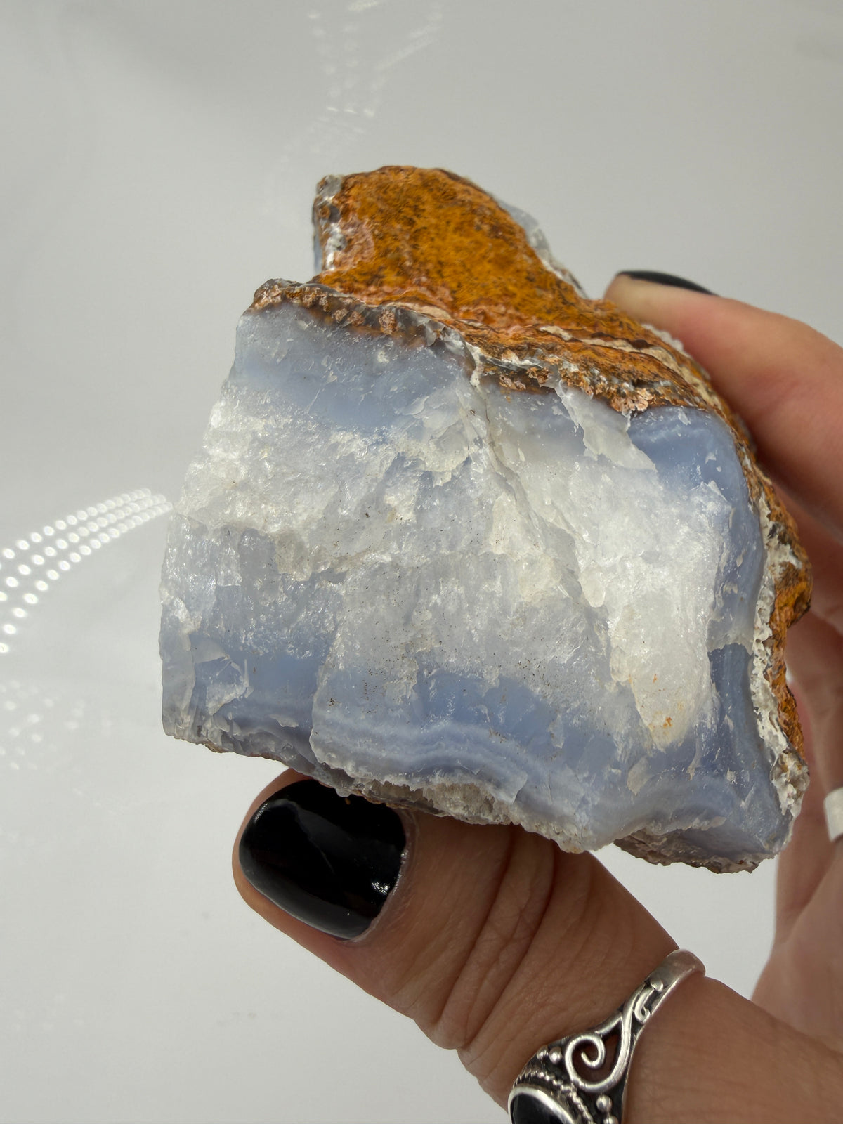 Blauer Chalcedon Rohstein BC46 mit sichtbarer Druze, ca. 8 × 8 × 6 cm, Nahaufnahme auf weißem Hintergrund