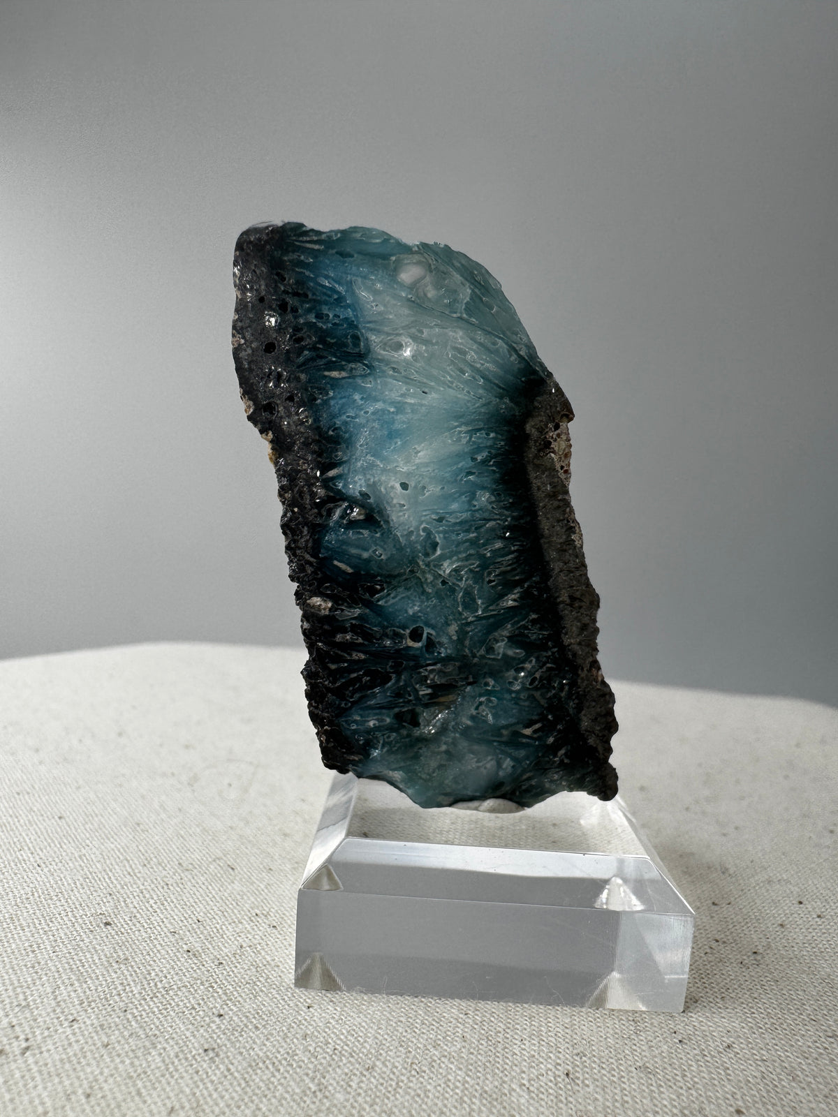 Eine Scheibe aus  Blue Ice Glacierite  mit polierter Oberfläche und charakteristischen Farbe von weiß, blau und schwarz. 