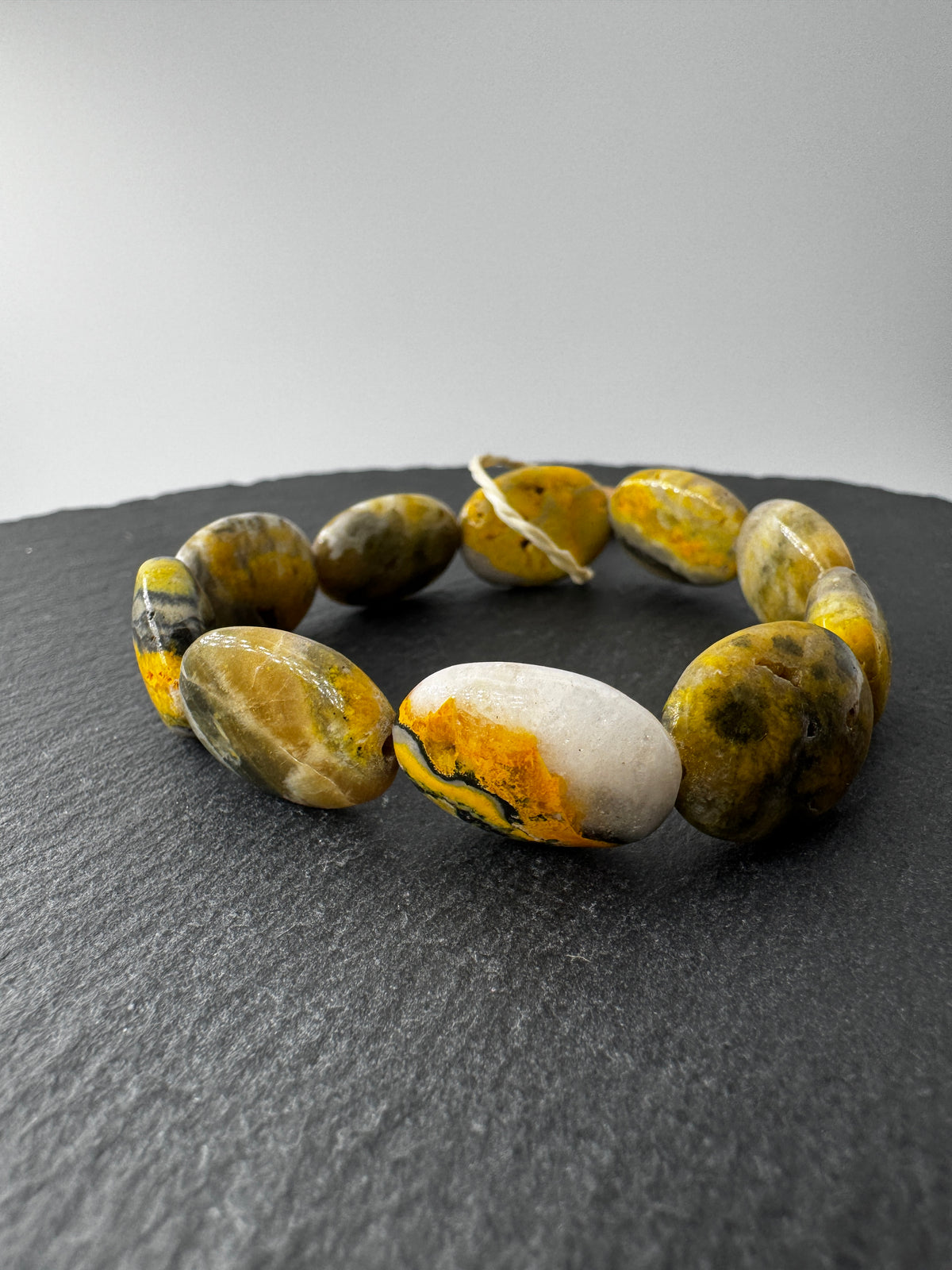 Armband aus Bumble Bee Jasper (Eclipse), ca. 19 cm Umfang, mit charakteristischer gelb-schwarz-oranger Bänderung