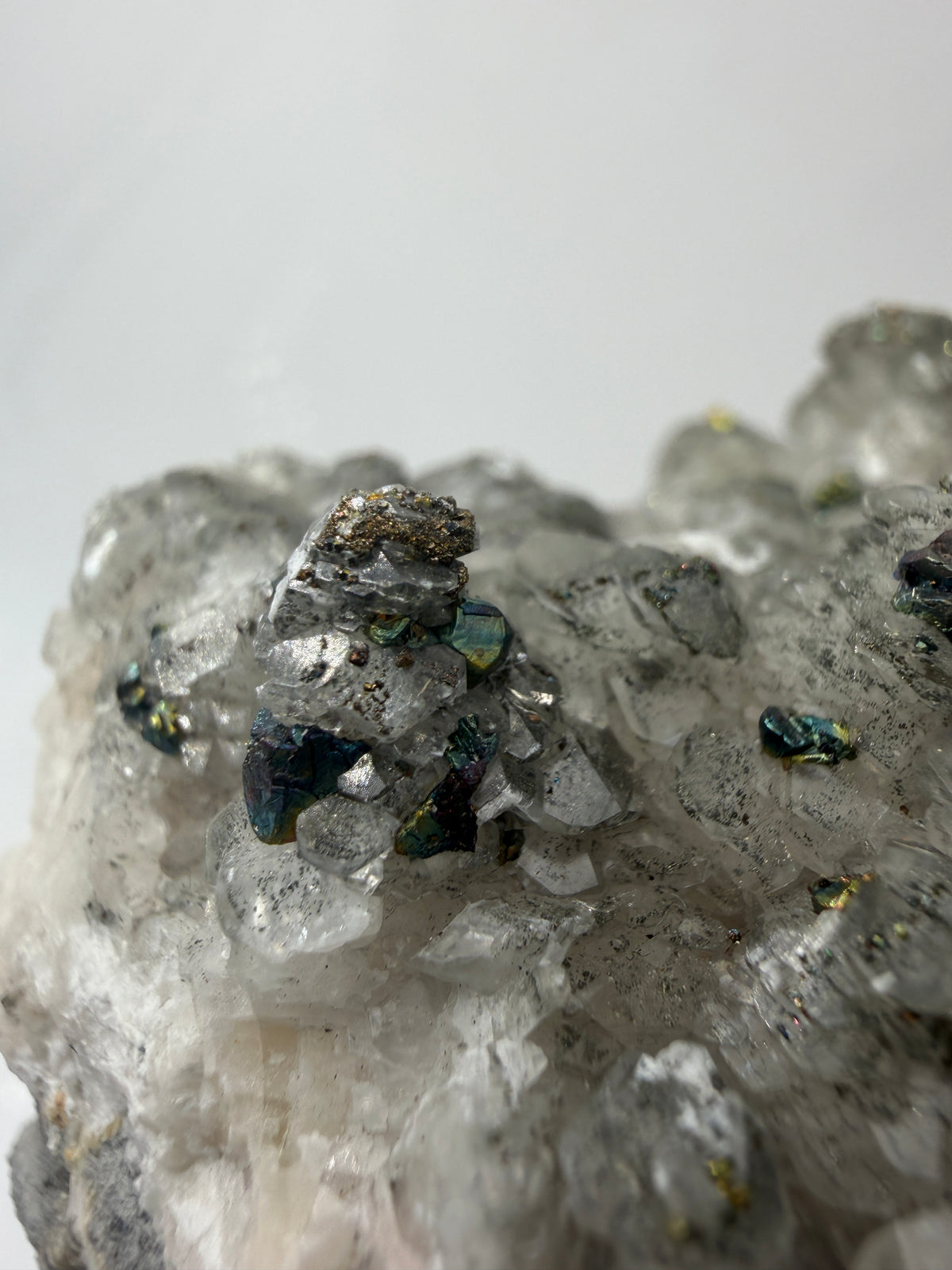 Weißer Calcit mit goldglänzenden Pyrit-Kristallen auf Gesteinsmatrix aus Herdringen, Sauerland.