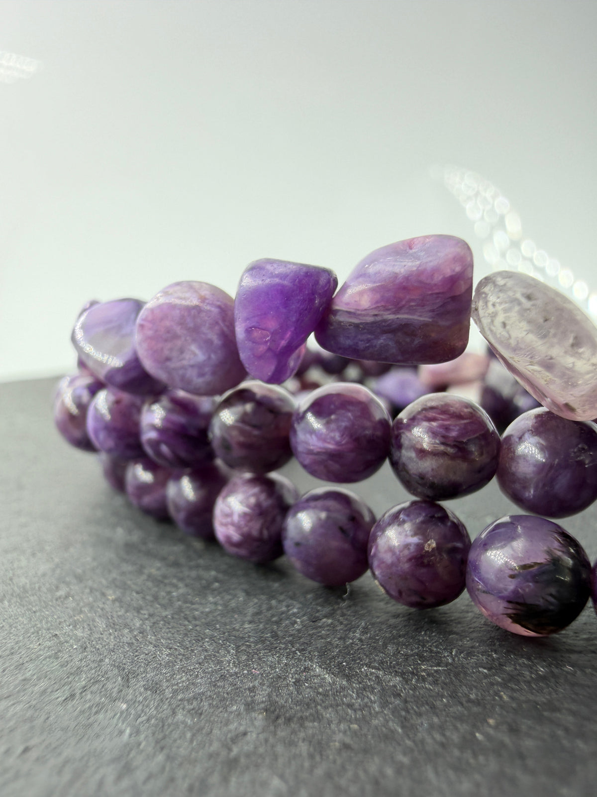 Ein hochwertiges Armband aus tiefvioletten Charoit-Perlen und Splittern, die eine faszinierende, wirbelförmige Maserung und einen sanften Perlmuttglanz aufweisen.