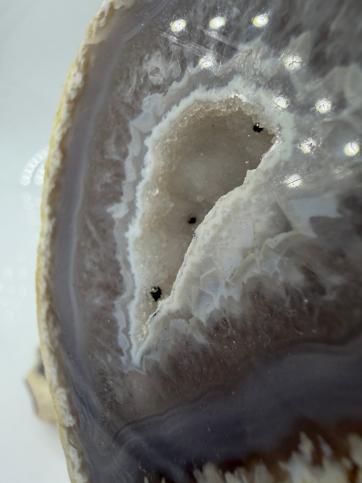 Detailansicht der kristallinen Quarzdruse im Inneren einer Achatgeode, zeigt terminierte Bergkristall-Spitzen.