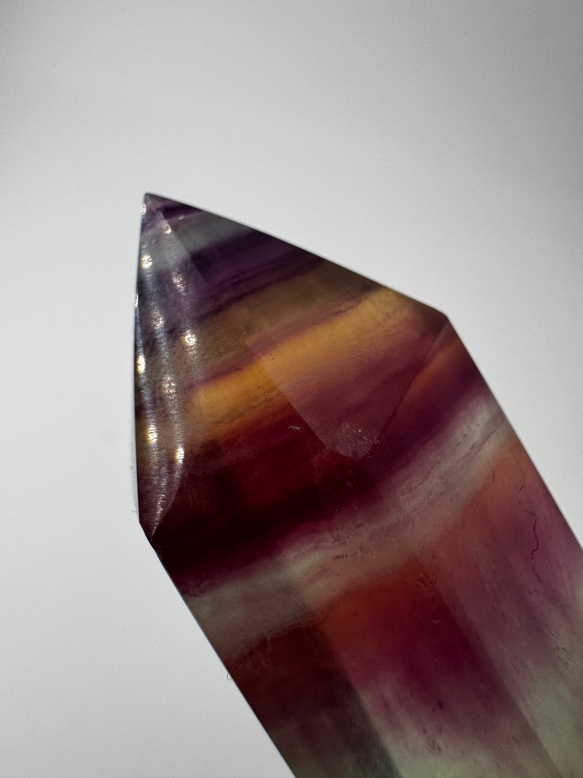 Geschliffene Fluorit-Spitze in Turmform mit natürlichem Farbspiel, Höhe 12,4 cm.