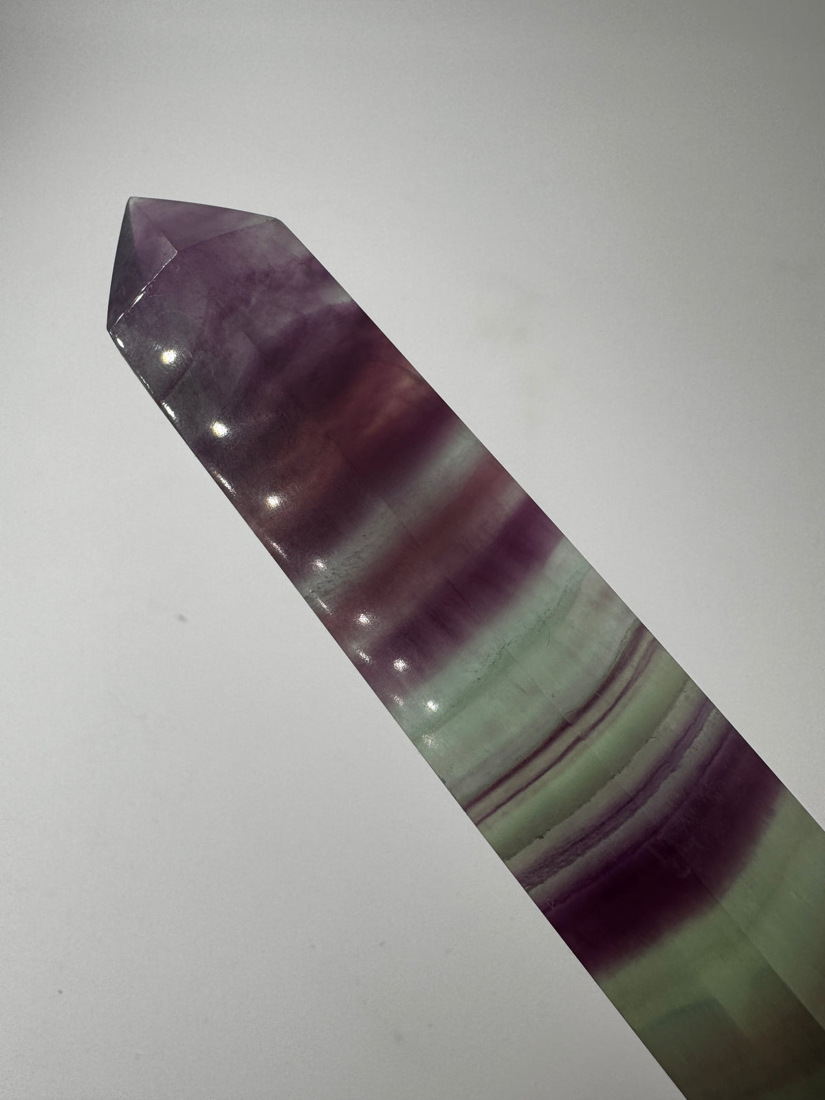 Geschliffene Fluorit-Spitze in Turmform mit natürlichem Farbspiel, Höhe 14 cm.
