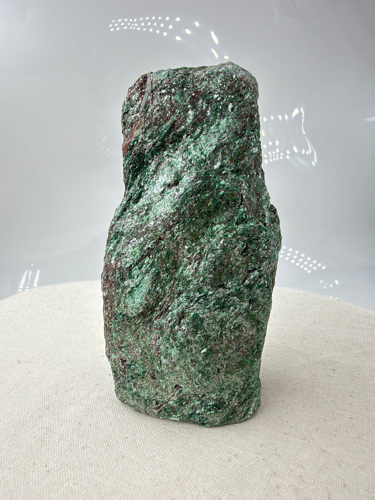 Länglicher grüner Fuchsit-Rohstein FP12 mit silbrig schimmernden Glimmerflächen und dunklen, bräunlichen Partien