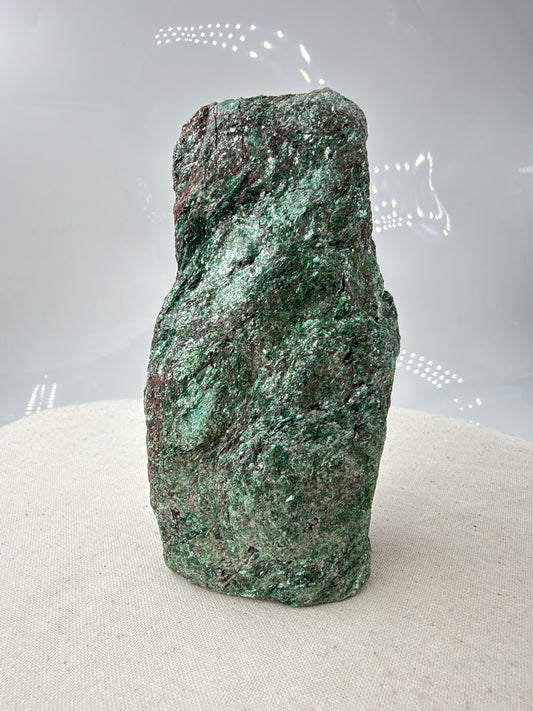 Länglicher grüner Fuchsit-Rohstein FP12 mit silbrig schimmernden Glimmerflächen und dunklen, bräunlichen Partien
