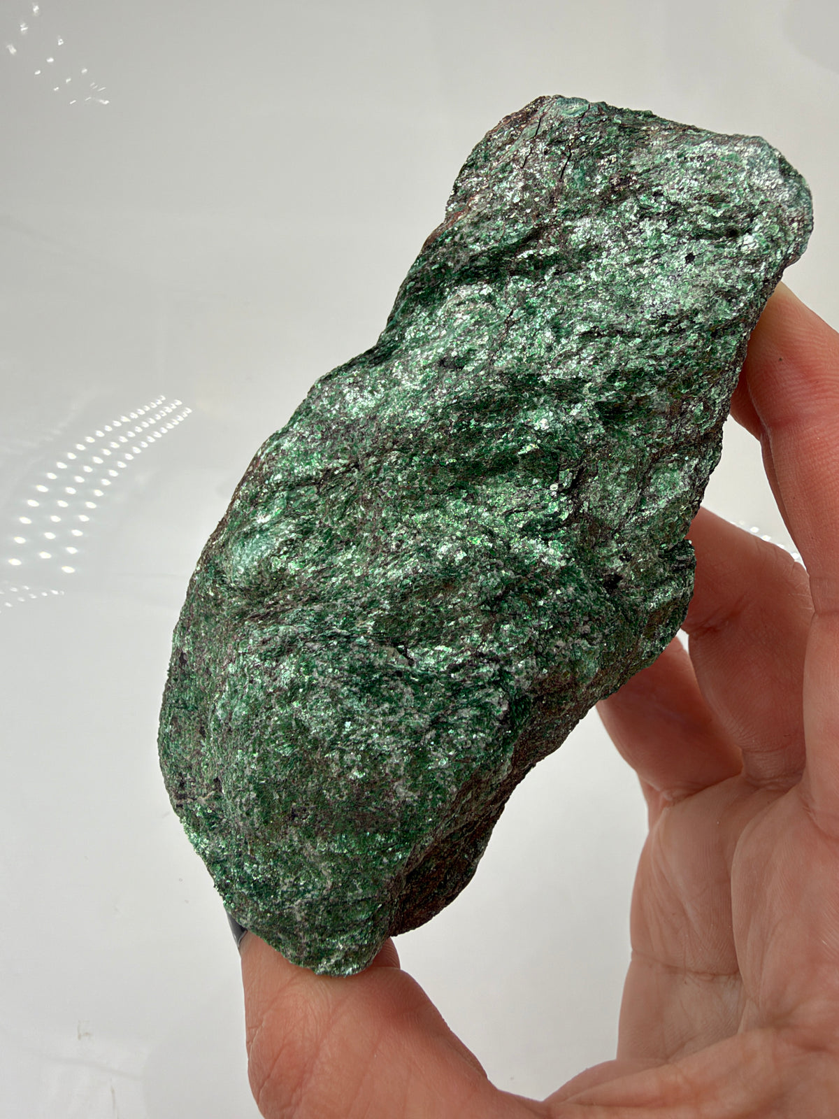 Länglicher grüner Fuchsit-Rohstein FP12 mit silbrig schimmernden Glimmerflächen und dunklen, bräunlichen Partien