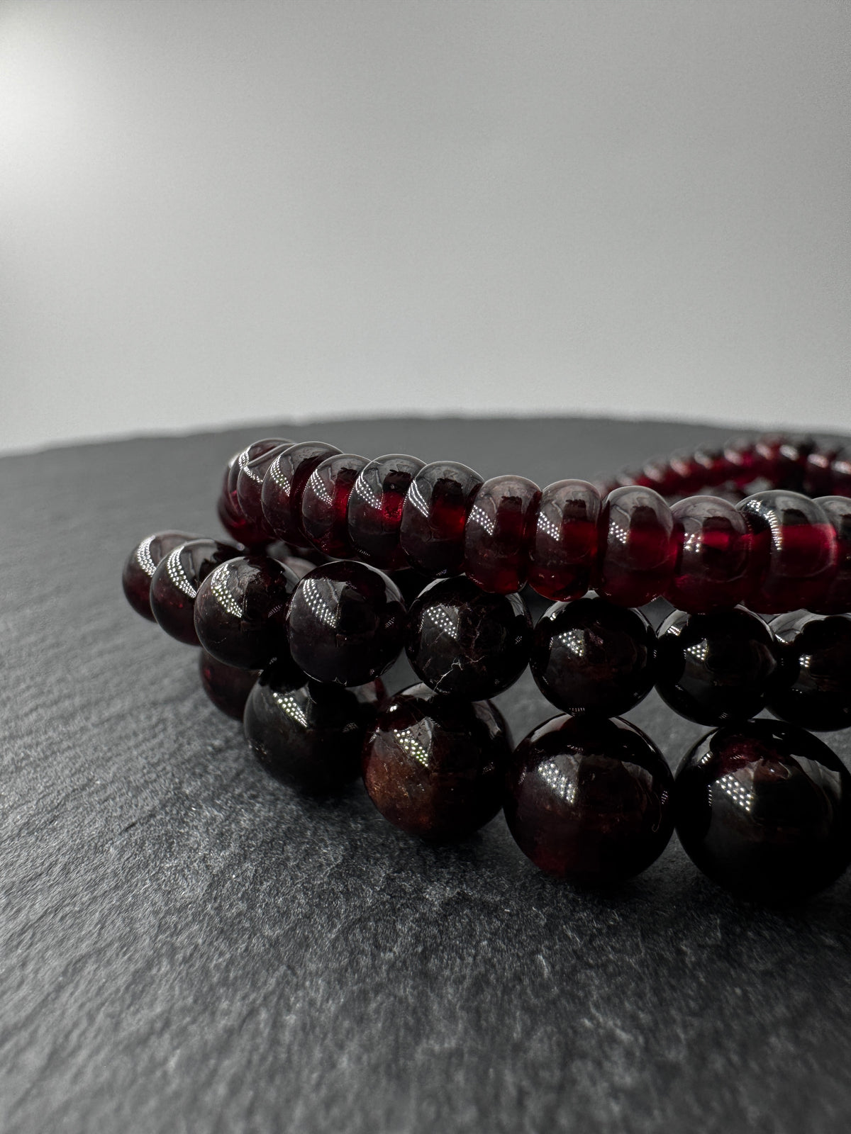 Ein filigranes Armband aus glänzenden, dunkelroten Granat-Kugeln.