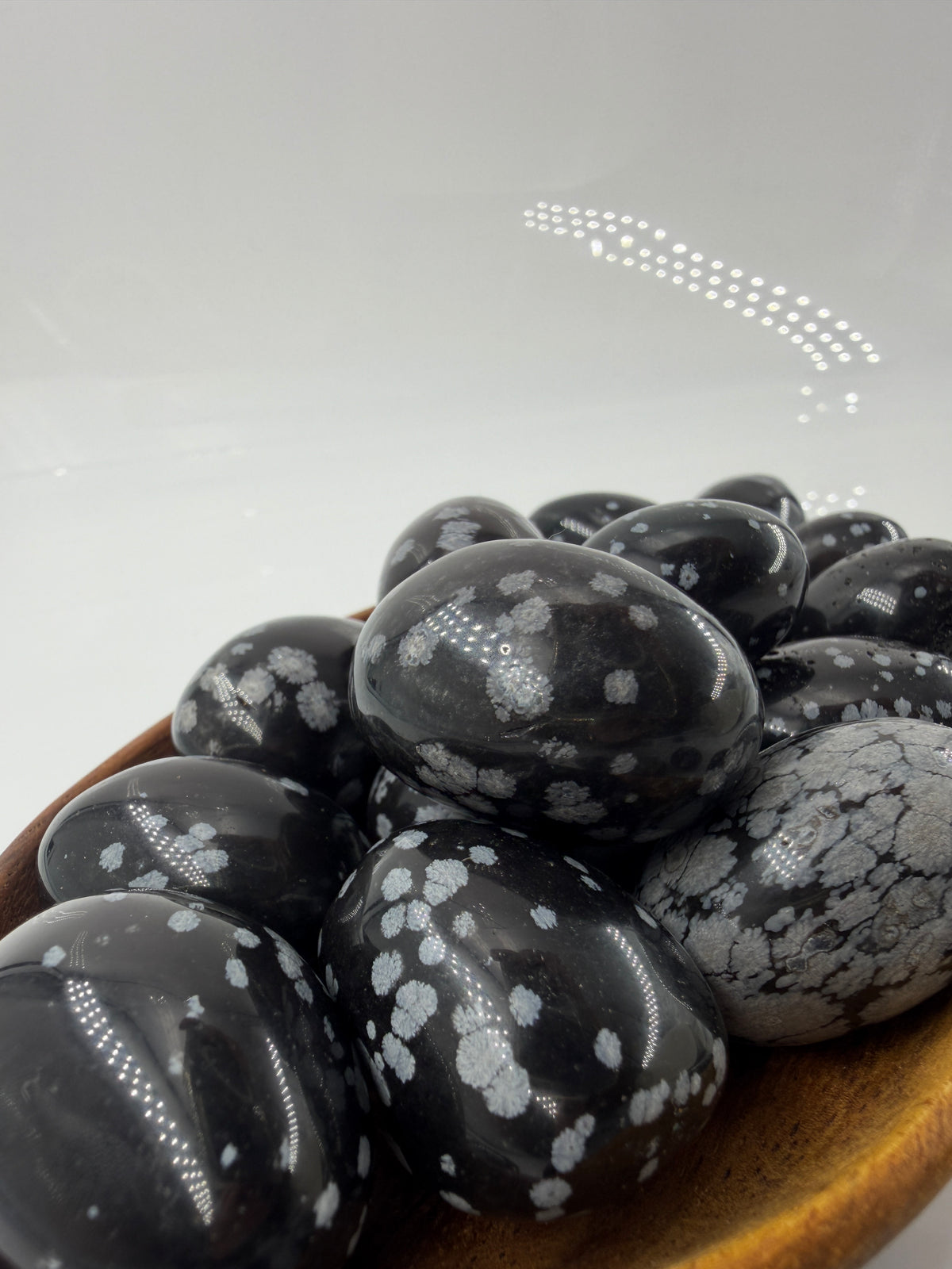 Polierte Schneeflocken-Obsidian Trommelsteine mit kontrastreichen weißen Cristobalit-Einschlüssen auf schwarzer Glasmatrix.