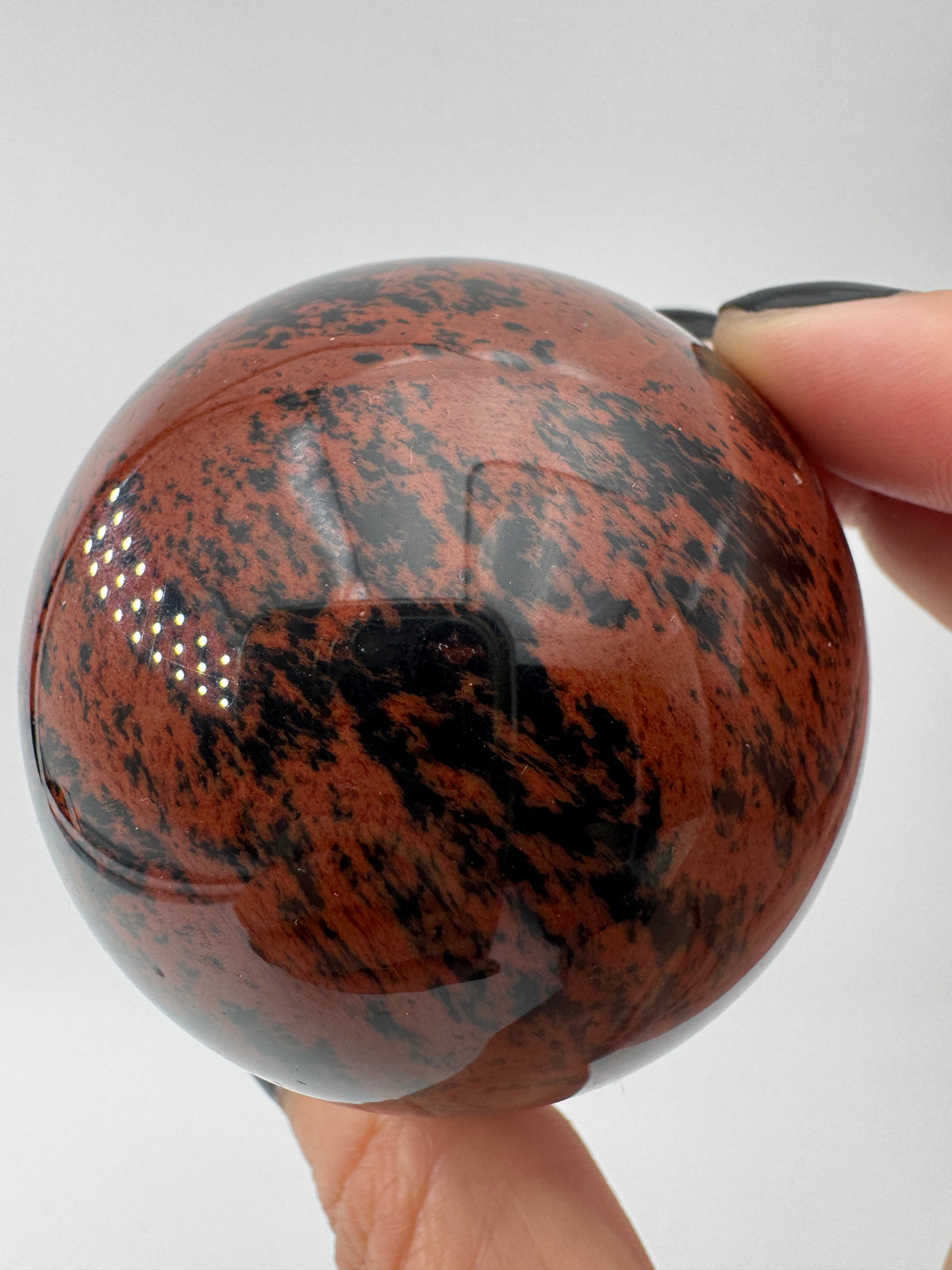 Polierte Kugel aus Mahagoni Obsidian mit rotbraun-schwarzer Maserung, Durchmesser 6 cm.