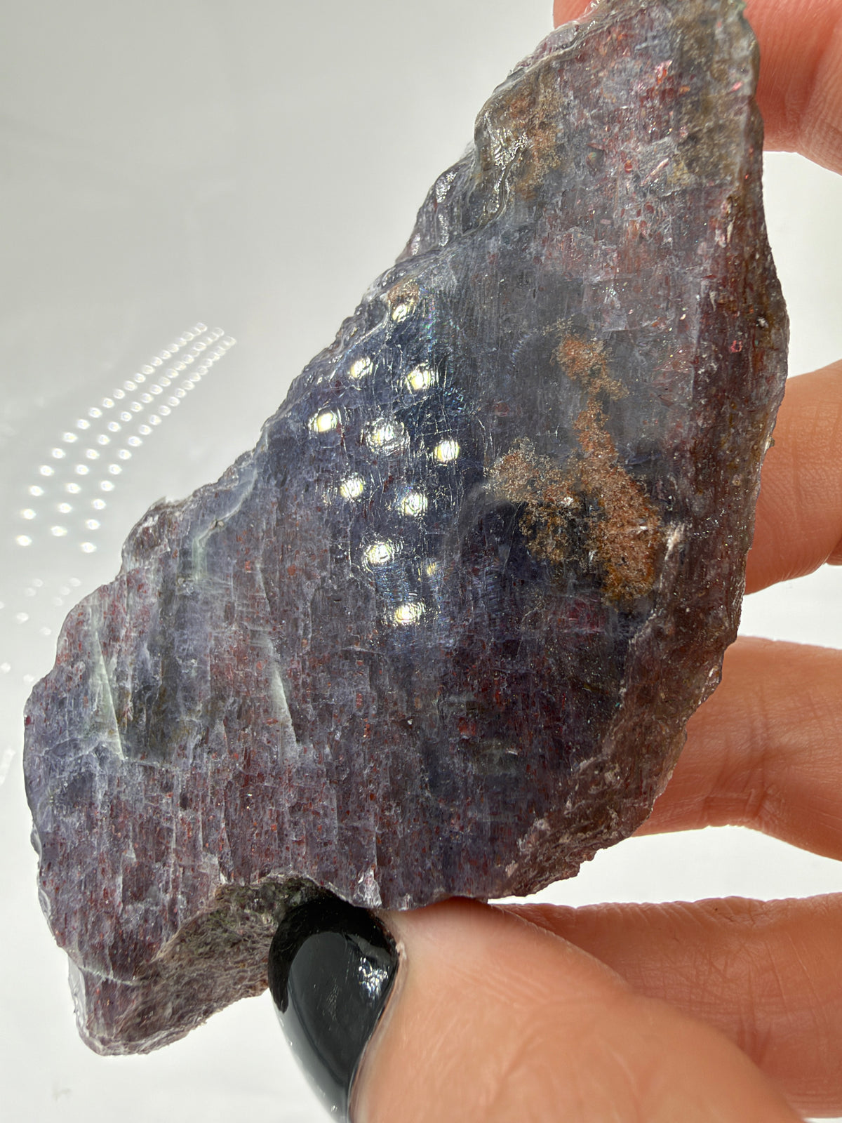 Rückseite einer länglichen Iolith-Sonnenstein-Scheibe IR39 mit grauvioletten Bereichen, feinen rötlichen Reflexen und unregelmäßigem Rand