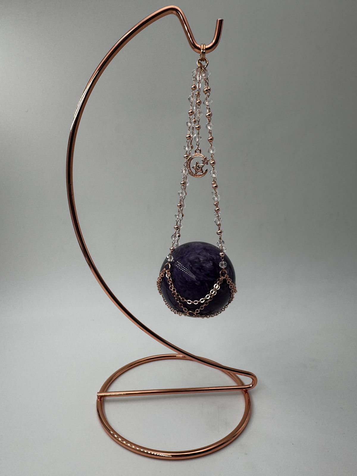 Roséfarbener Metallständer für Mineralkugeln, Höhe 23,5 cm, mit einer Beispielkugel von 4,7 cm Durchmesser.