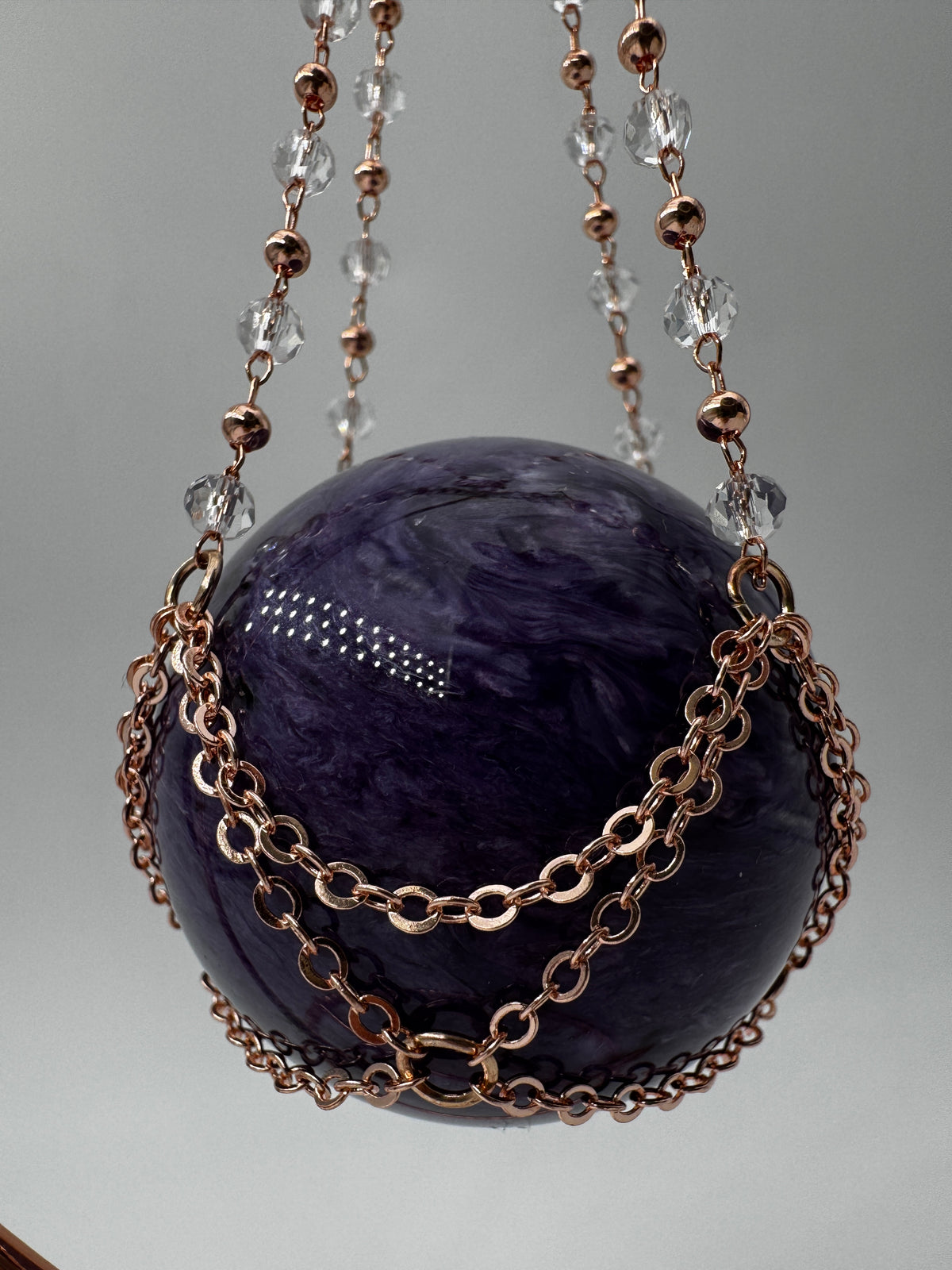 Roséfarbener Metallständer für Mineralkugeln, Höhe 23,5 cm, mit einer Beispielkugel von 4,7 cm Durchmesser.