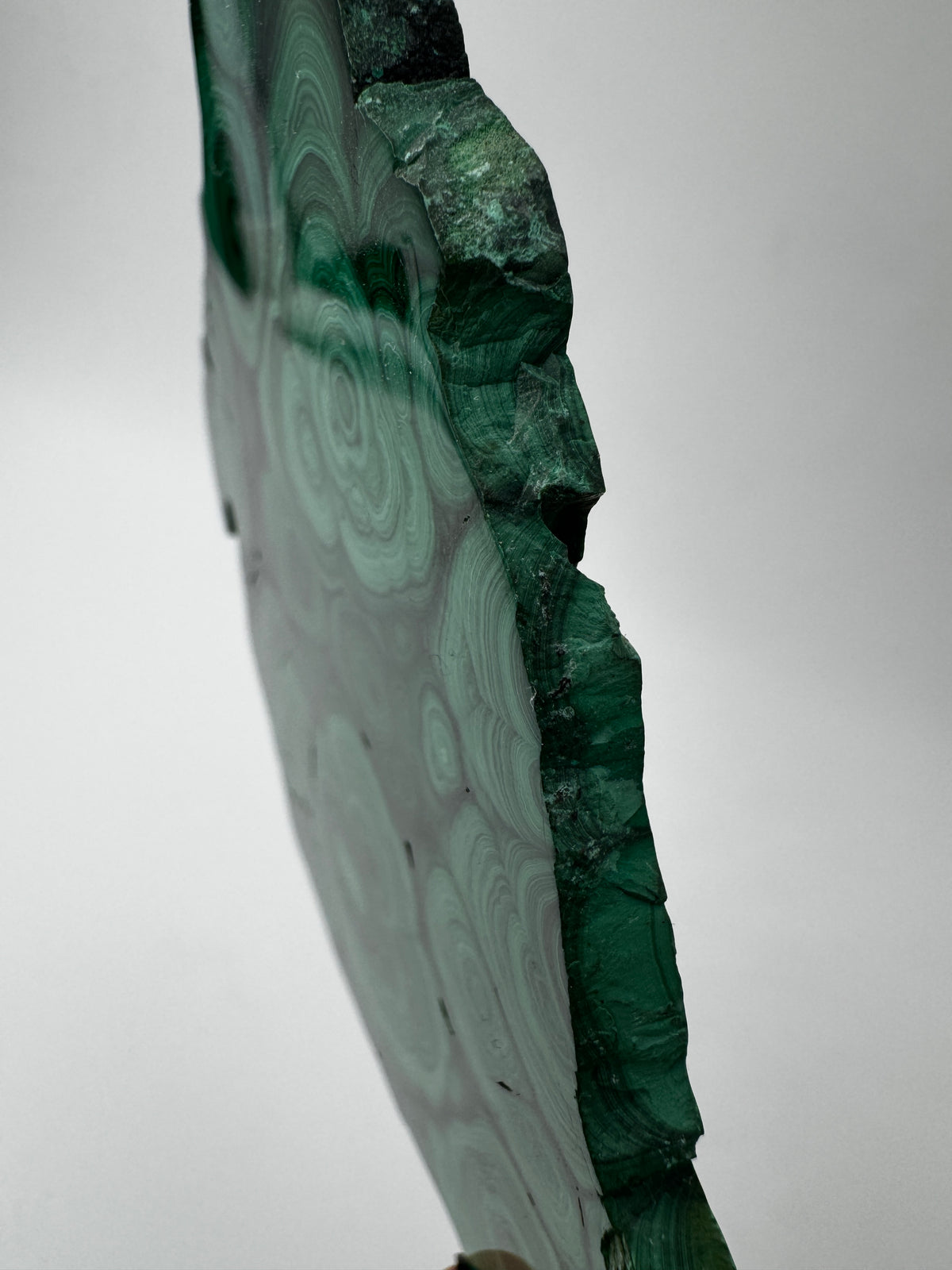 Beidseitig polierter Malachit-Anschliff mit konzentrischen grünen Bändern, 12 × 8 × 0,6 cm, natürliche Seiten.
