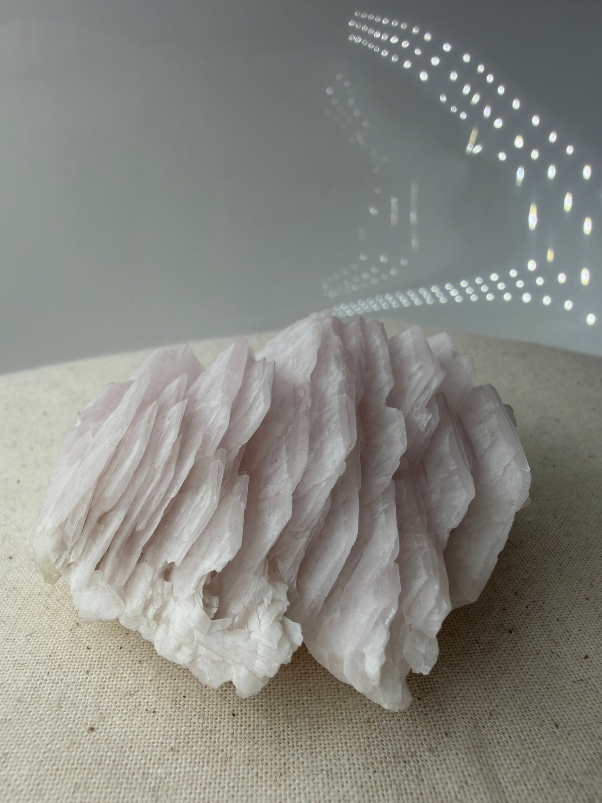 Naturbelassener Rohstein aus Mangano-Calcit in zartem Rosa mit sichtbaren Spaltflächen.