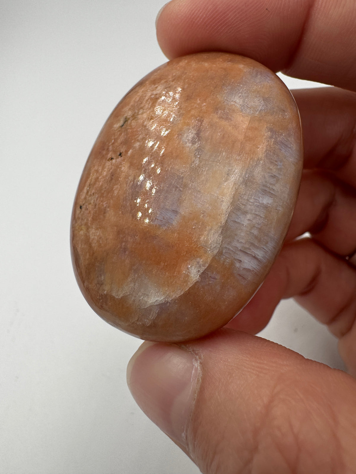 Polierter Scheibenstein aus Mondstein, 4,7 x 3,4 cm – transparentes Mineral mit sanftem blauem Adulareszenz-Schimmer auf glatter Oberfläche.
