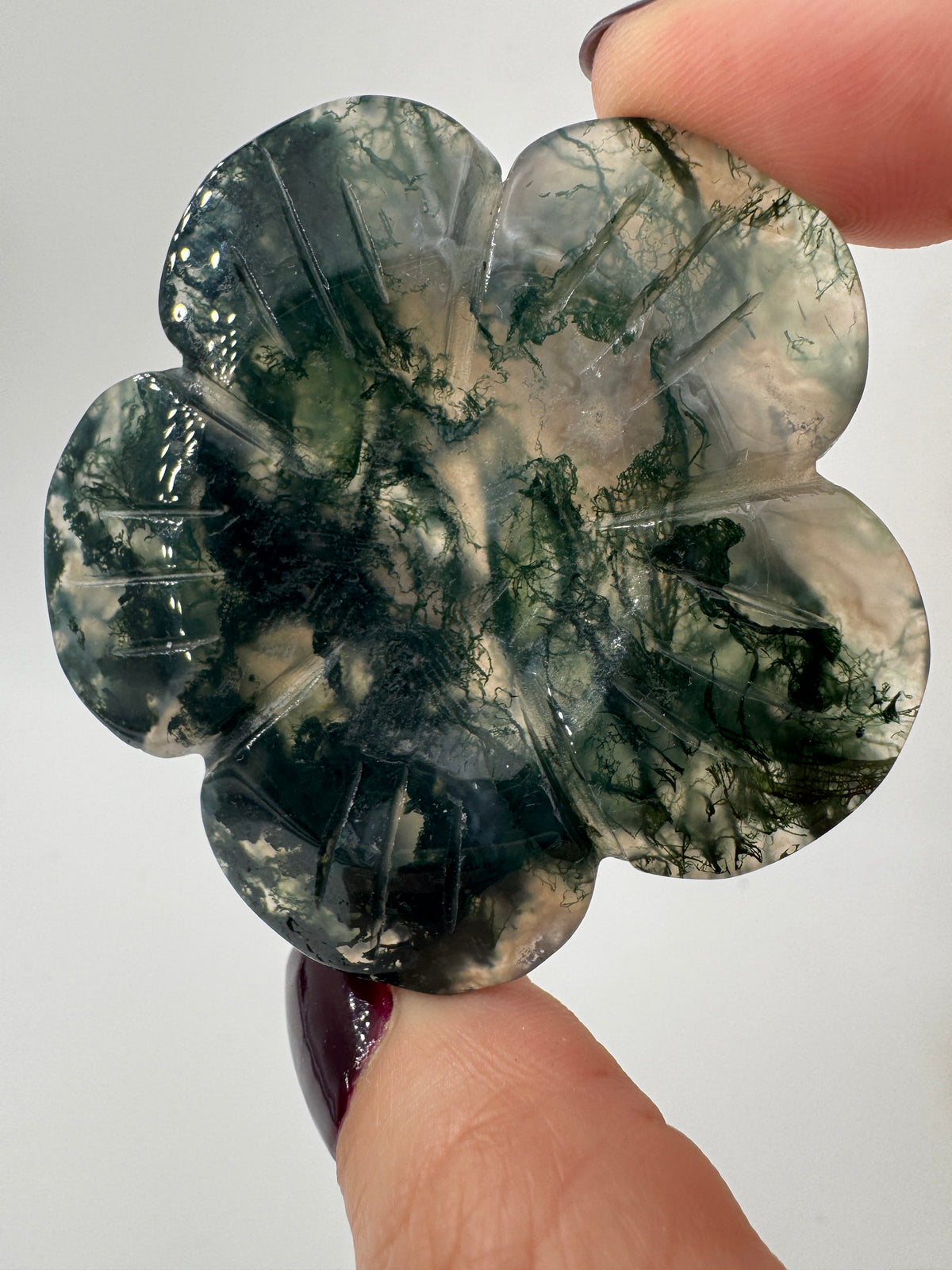 Fein gearbeitetes Blumen-Carving aus Moosachat mit charakteristischer grünlicher Dendritenzeichnung, Durchmesser ca. 5,4 cm, auch als Kugelständer nutzbar.