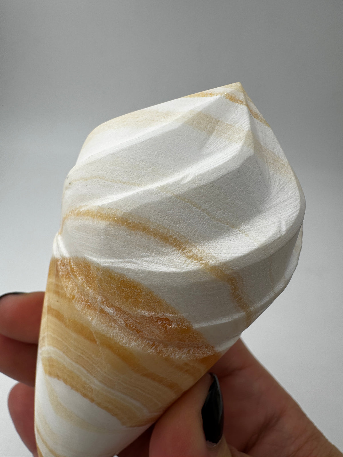 Orangencalcit-Carving OE36 in Softeis-Waffelform mit warmer Transluzenz.