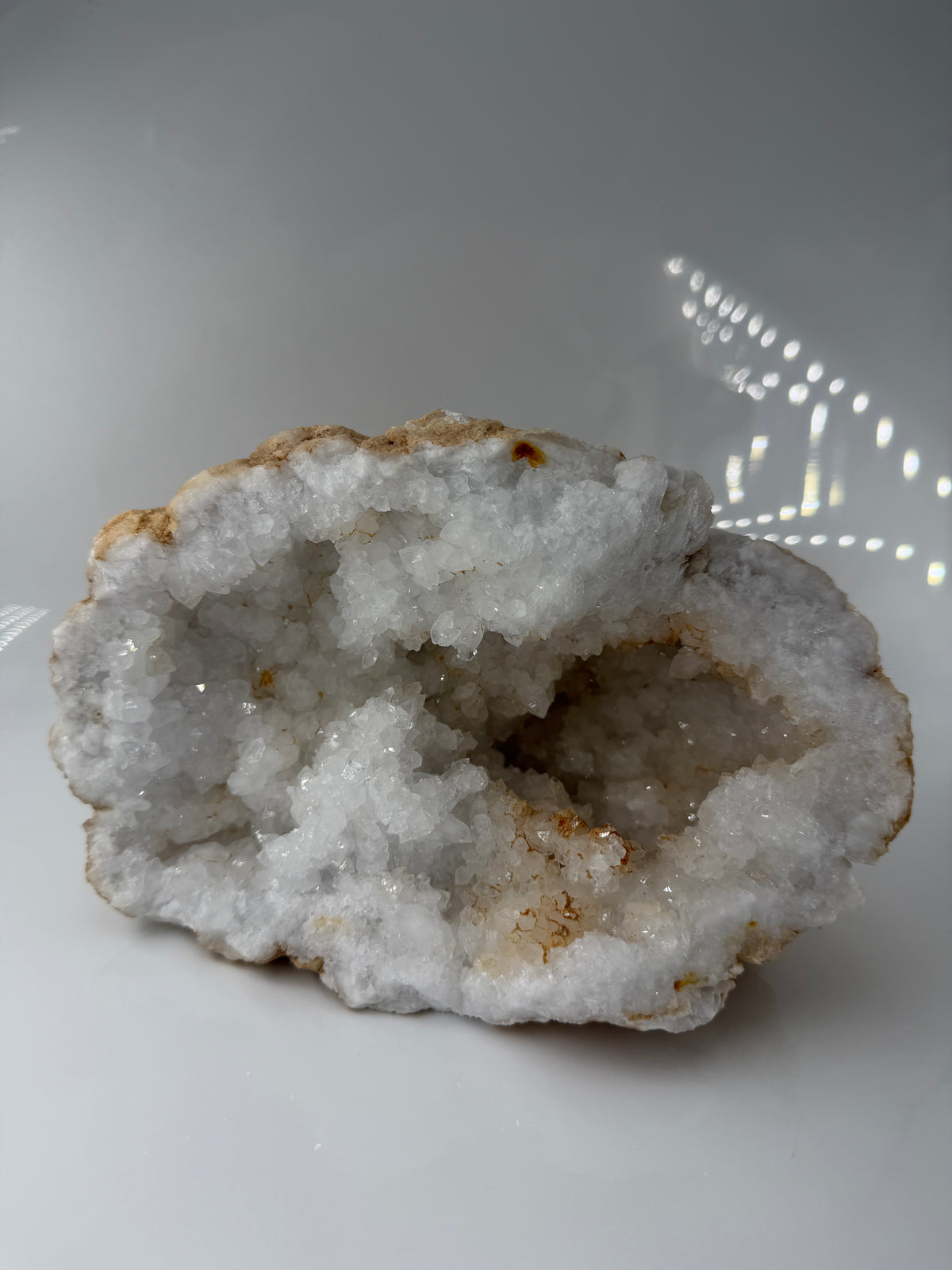 Offene Quarzgeode mit zahlreichen, klar terminierten Bergkristall-Spitzen im Inneren eines Gesteinshohlraums.
