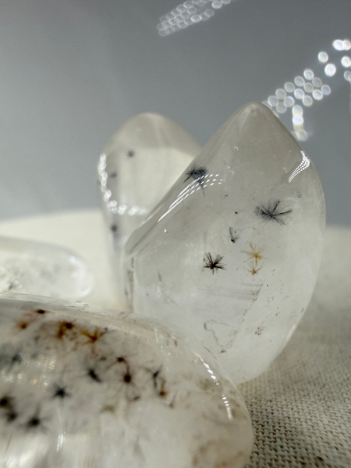 Hollandit mit Quarz: schwarze, nadelförmige Hollandit-Einschlüsse in klarem bis milchigem Quarz, geschliffen, ca. 1,5–3 cm – Qualität AA 