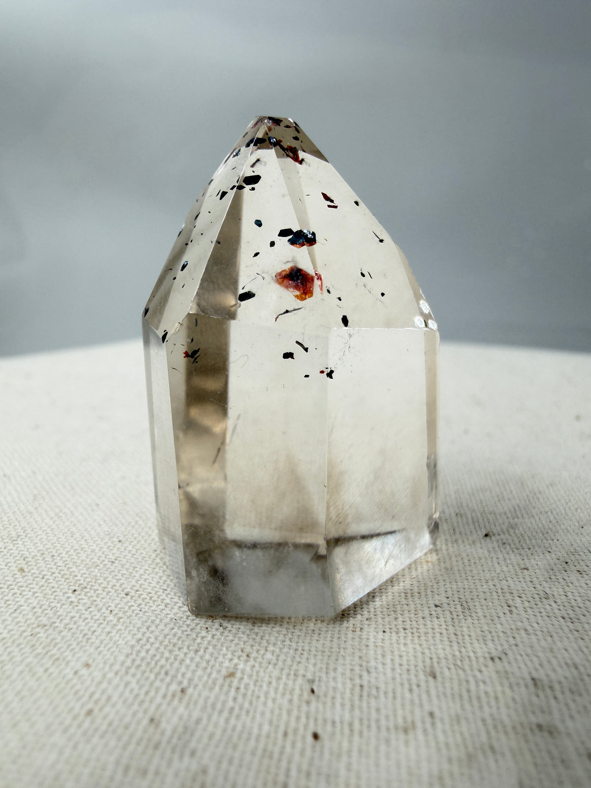Quarz Spitze mit Hämatit-Plättchen QH12, 3,5 cm Höhe, mit silbrig glänzenden Hämatit-Einschlüssen im transparenten Quarz.