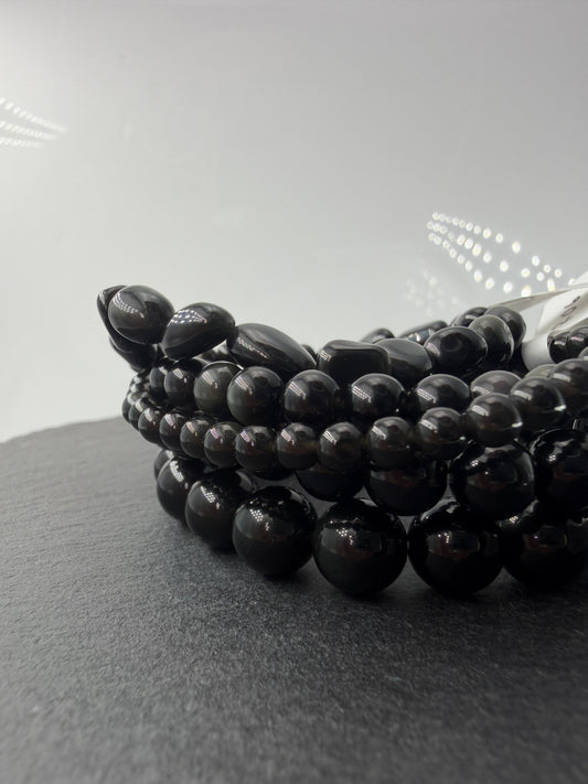 Kugelarmband aus Regenbogen-Obsidian mit irisierenden Farbringen in Violett und Grün.