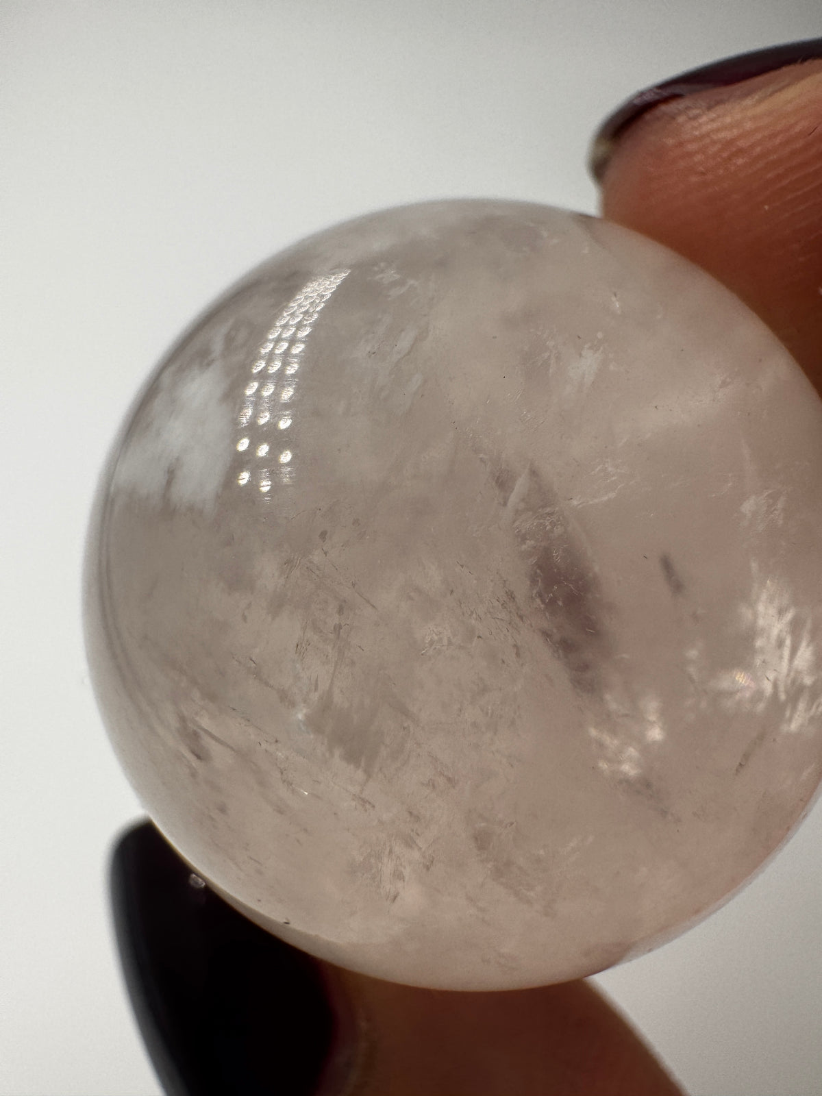 Rosenquarz-Kugel in Zartrosa mit weißen Einschlüssen, Ø 2,7 cm.