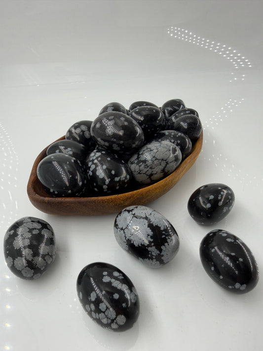 Polierte Schneeflocken-Obsidian Trommelsteine mit kontrastreichen weißen Cristobalit-Einschlüssen auf schwarzer Glasmatrix.