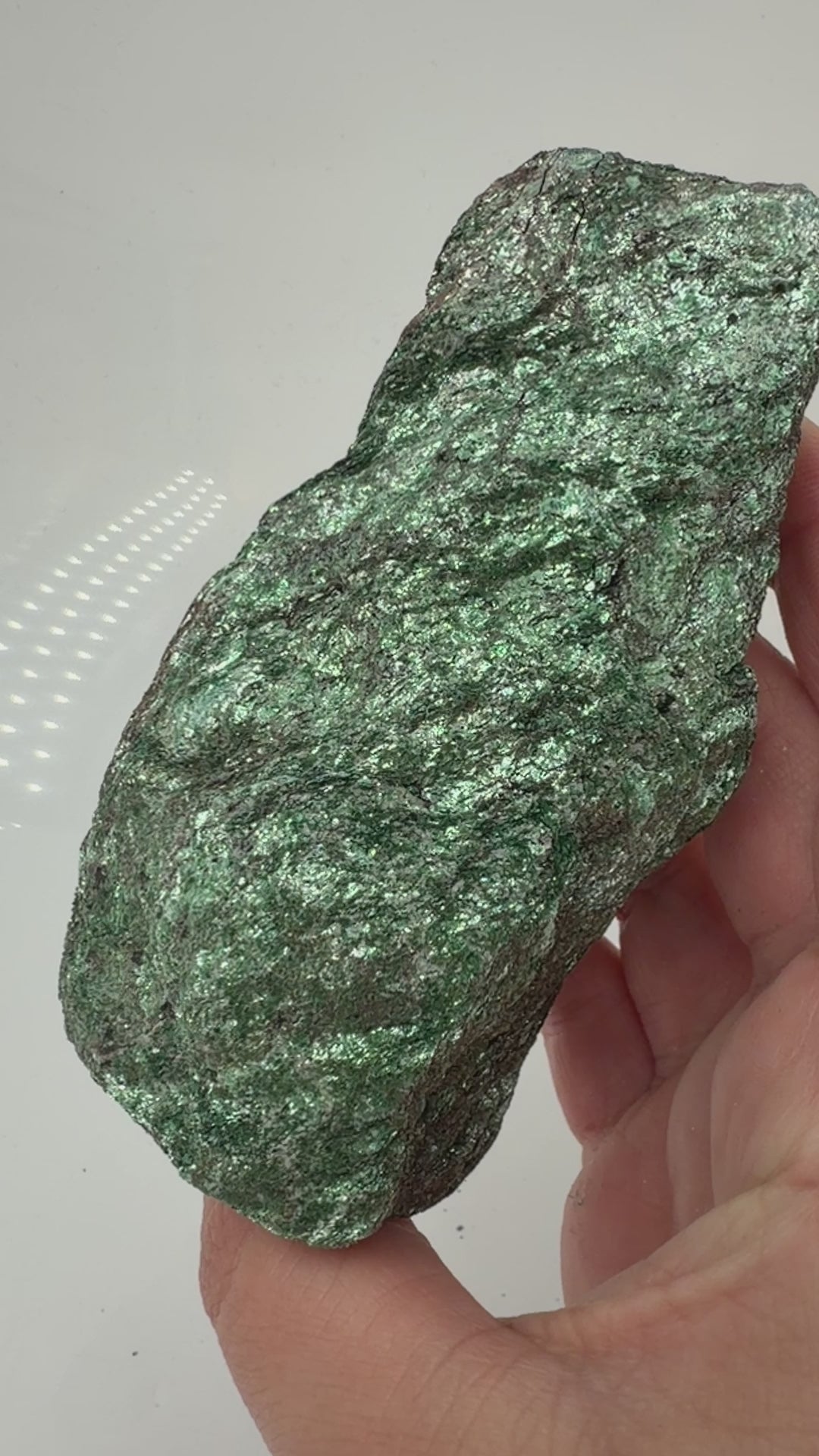 Länglicher grüner Fuchsit-Rohstein FP12 mit silbrig schimmernden Glimmerflächen und dunklen, bräunlichen Partien