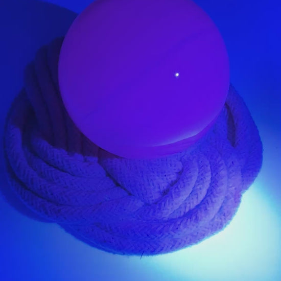 Handpolierte Mangano Calcit Kugel MK53 in zartrosa mit perlmuttartigem Glanz und UV-Fluoreszenz, Durchmesser 5,9 cm.
