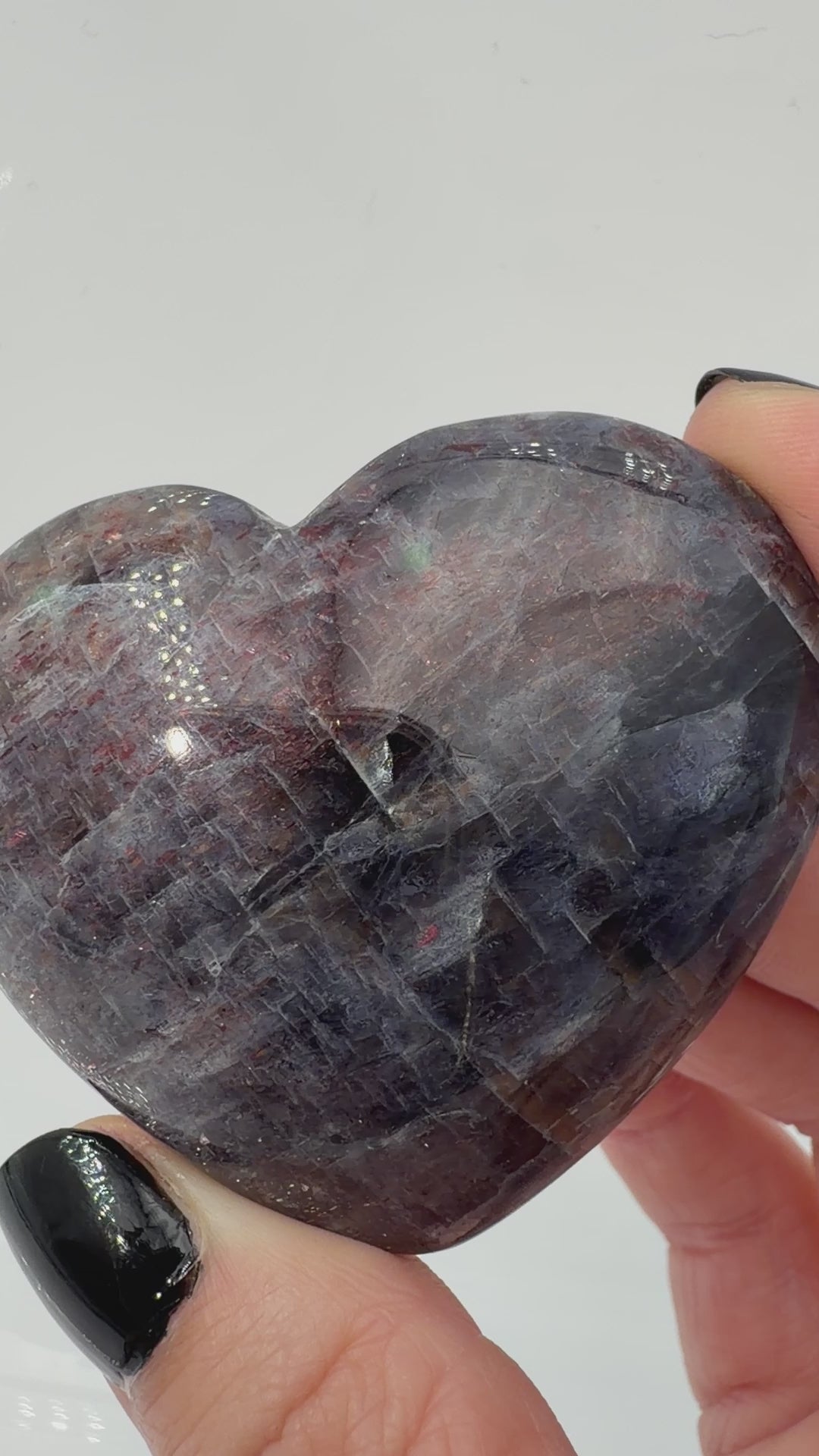 Ein Herz aus dunkelblauem Iolith, mit Sonnenstein. Die glatte Oberfläche zeigt je nach Lichteinfall einen metallischen Glanz und die charakteristischen Farbumschläge der beiden Mineralvarianten.