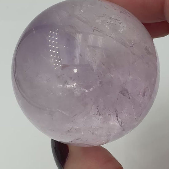 Handpolierte Amethyst-Kugel AK34 mit zartem Violett und feinen Zonarstrukturen.