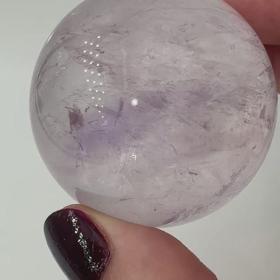 Handpolierte Amethyst-Kugel AKB32 mit zartem Violett und feinen Zonarstrukturen.