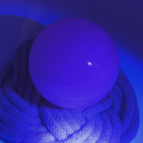 Handpolierte Mangano Calcit Kugel MK39 in zartrosa mit perlmuttartigem Glanz und UV-Fluoreszenz, Durchmesser 5,4 cm.