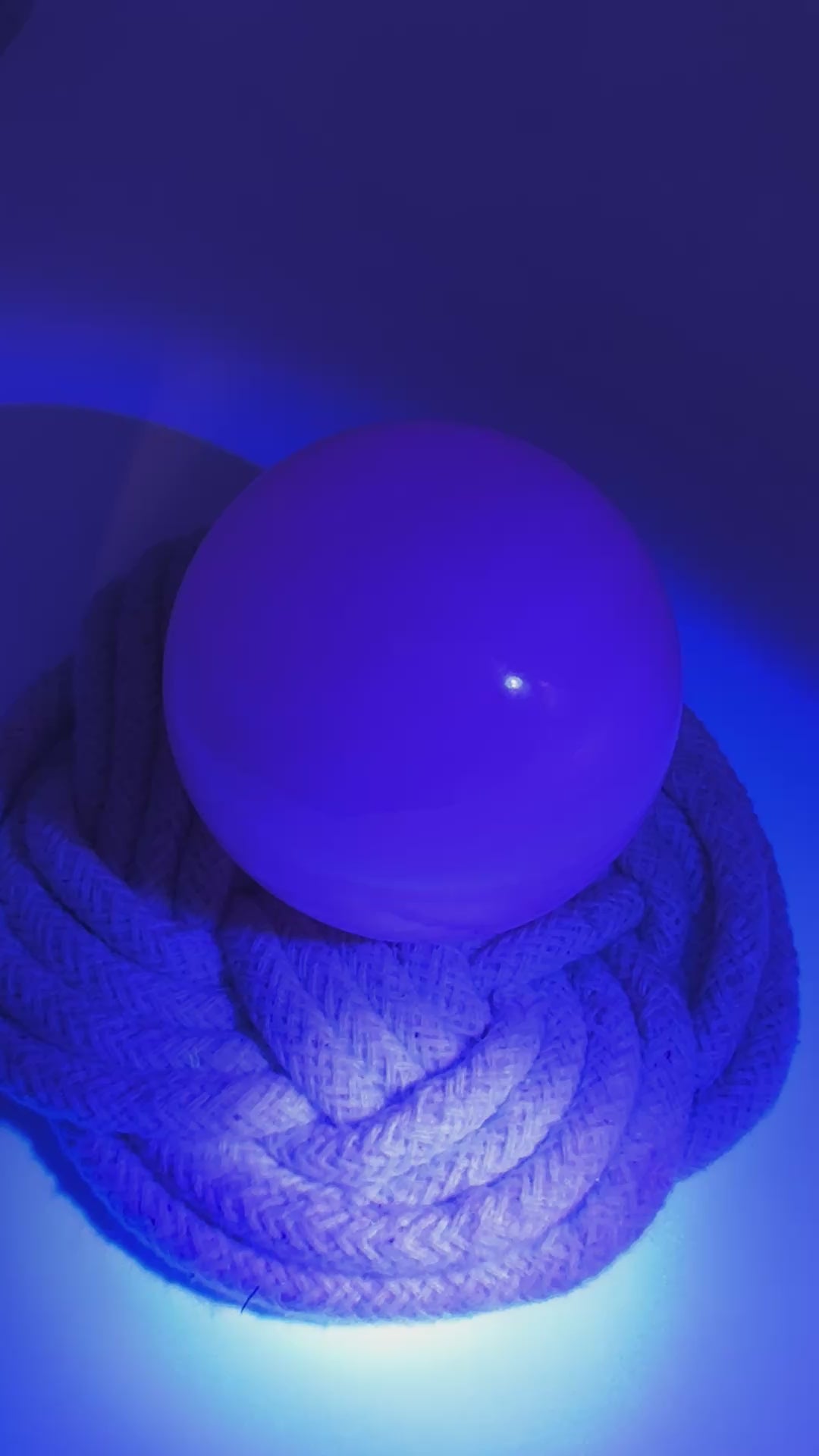 Handpolierte Mangano Calcit Kugel MK39 in zartrosa mit perlmuttartigem Glanz und UV-Fluoreszenz, Durchmesser 5,4 cm.
